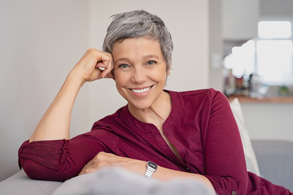 Mature woman smiling on a couch 